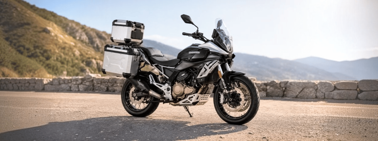 Motocicleta con equipaje estacionada en una carretera de montaña