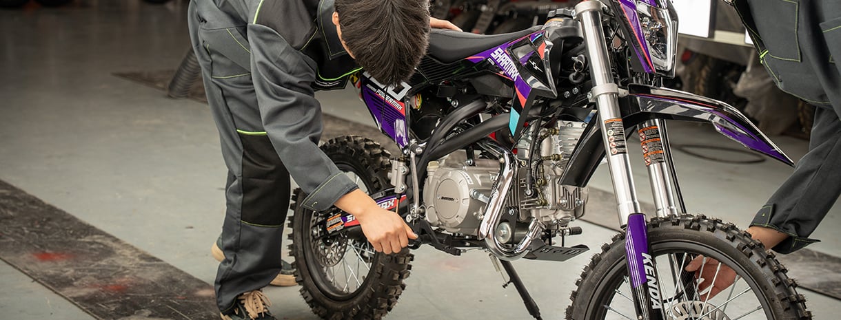 Engineers perform a technical check on a Sharmax motorcycle